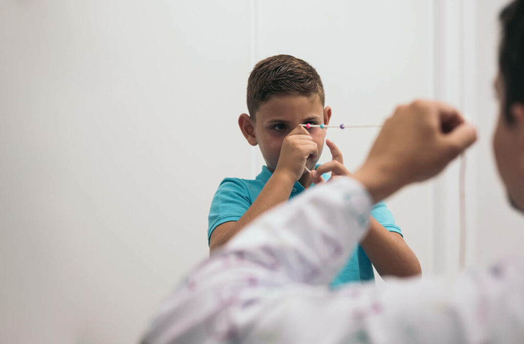 A young boy and his optometrist at opposite ends of a brock string during vision therapy.