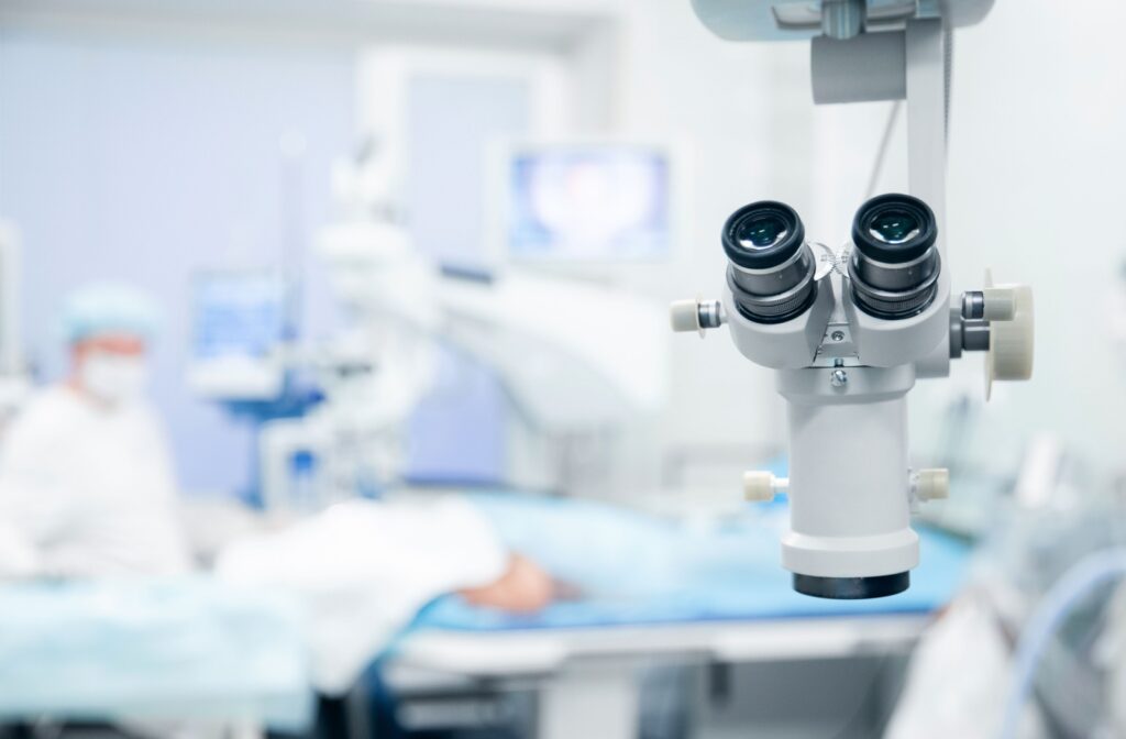 View of a LASIK surgery room, with a piece of equipment in the foreground and the patient and the doctor out-of-focus in the background.